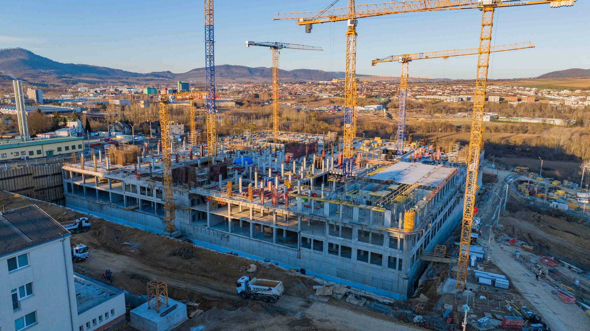 Žeriavy nad stavbou nemocnice v Prešove pri západe slnka