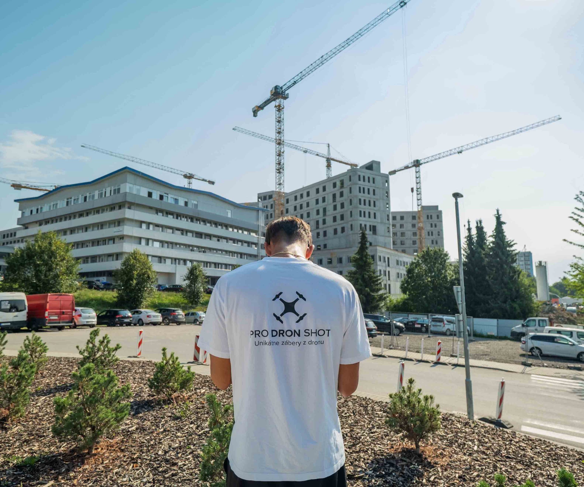 Člen tímu PRO DRON SHOT pred staveniskom nemocnice