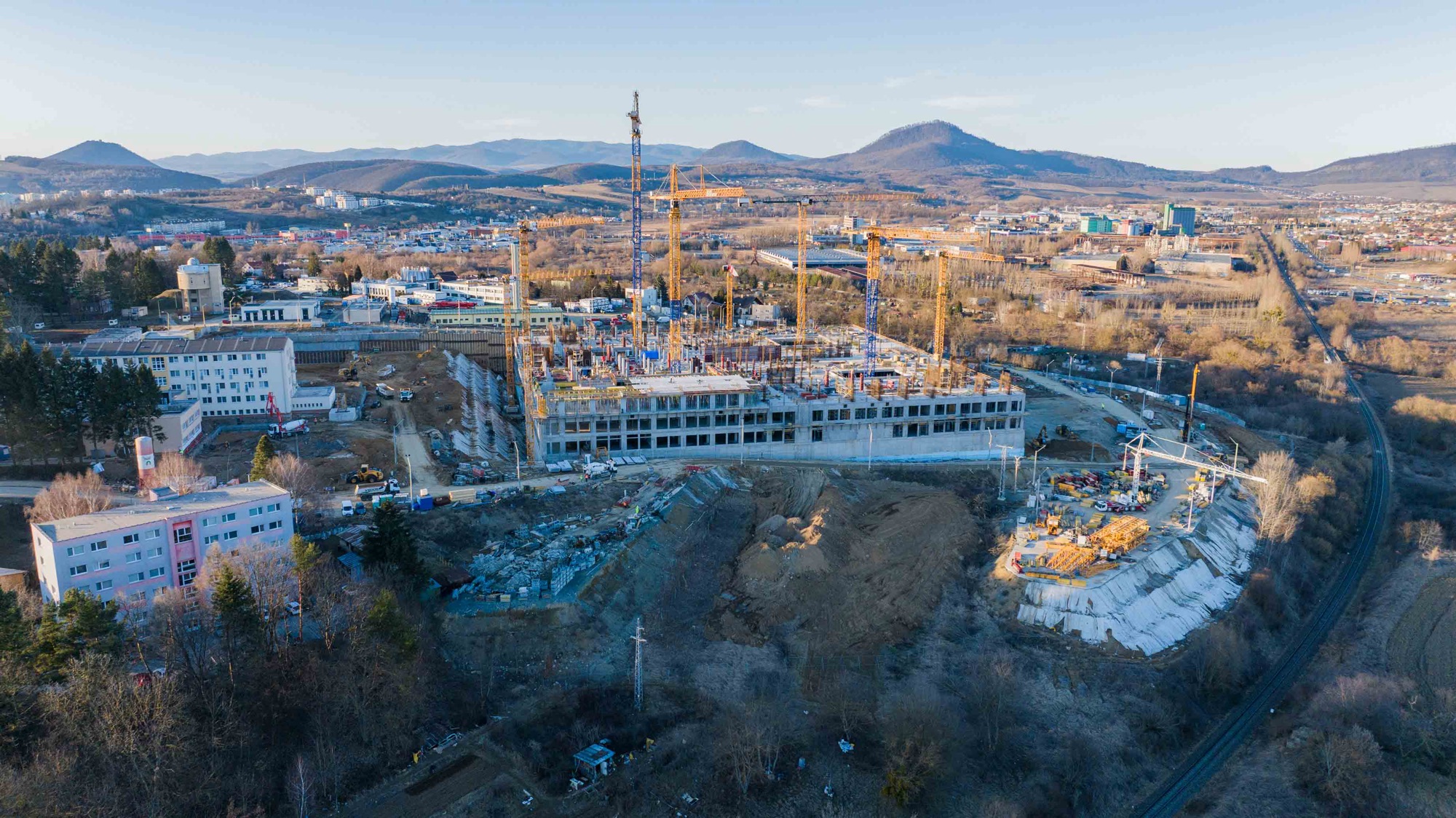 Stavenisko nemocnice v Prešove s horami v pozadí pri západe slnka